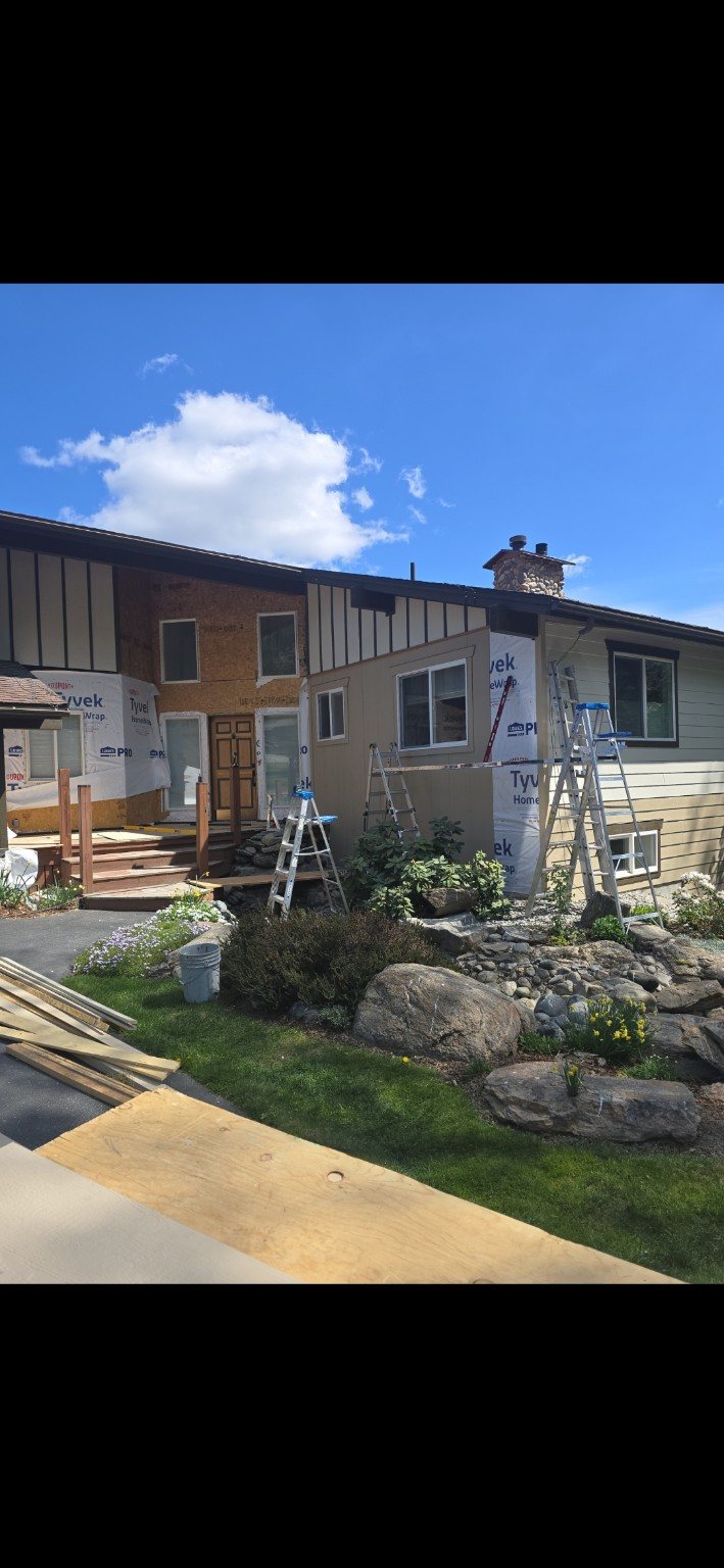 Cedar entry renovation during construction with exposed weather barrier and ladders